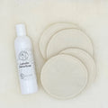 White bottle of Lanolin Soap with four round white pads on a beige background