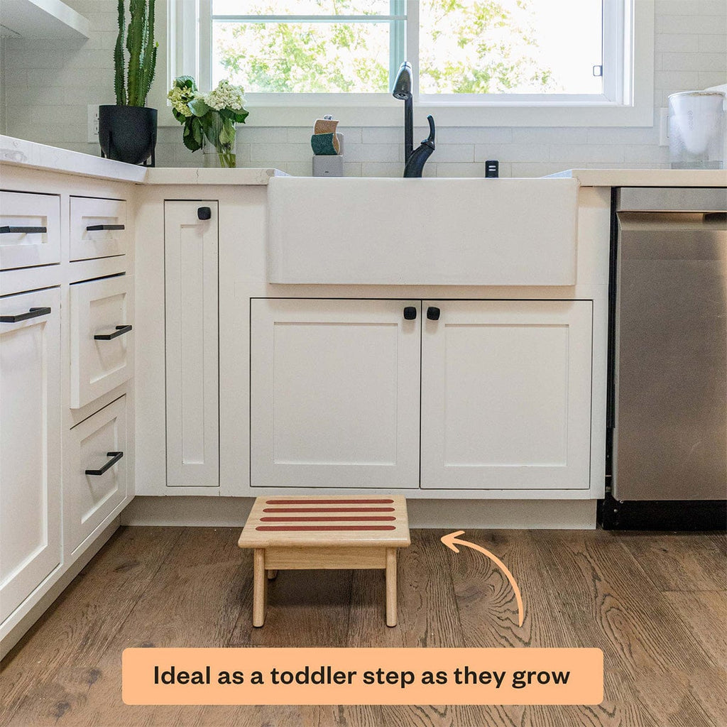 Kitchen with a wooden step stool placed on the floor, ideal for toddlers.