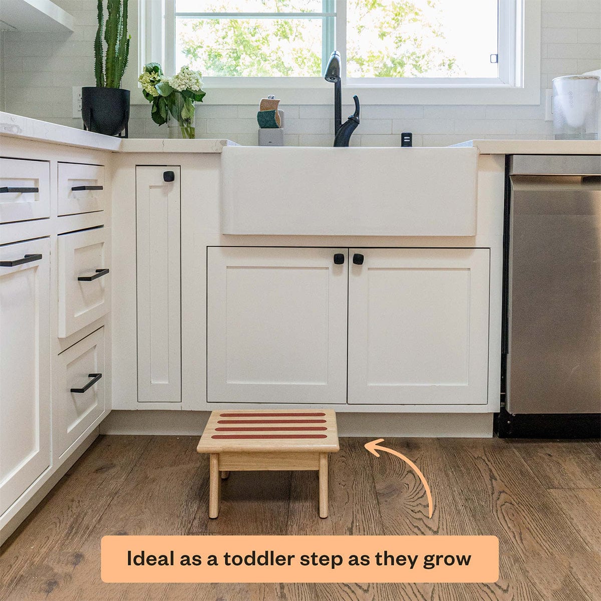 Kitchen with a wooden step stool placed on the floor, ideal for toddlers.